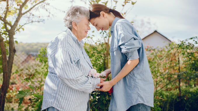 Old woman in a garden with young granddaughter